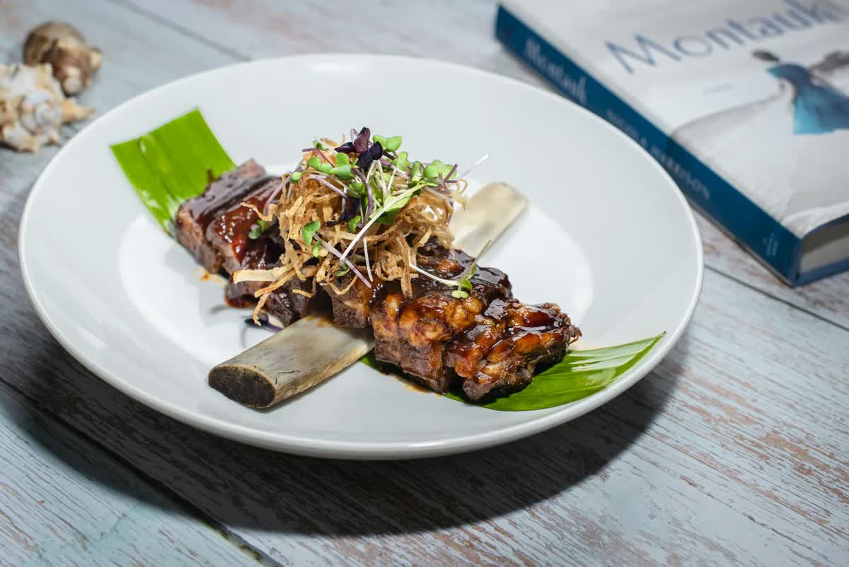 Short ribs plated at Montauk Restaurant beside the Montauk book