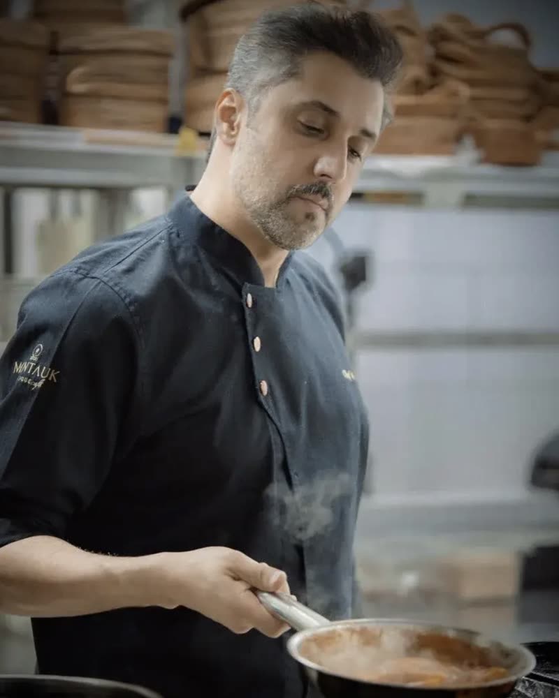Mohammed Fadhel Al Asfoor cooking at the stove in a Montauk chef coat