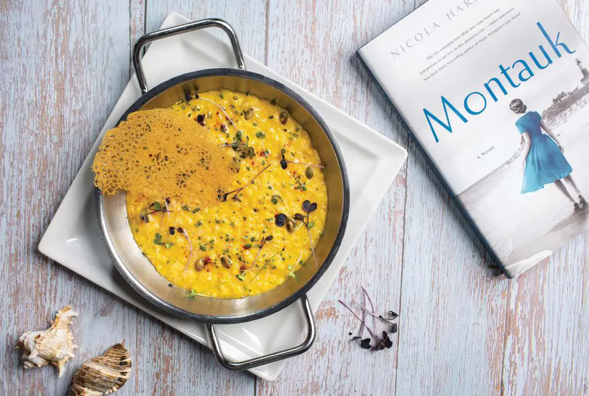 Saffron machboos in a copper pan beside the Montauk book