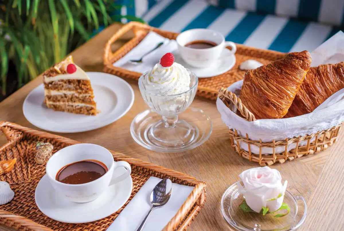 Cake, a sundae and coffee on a woven tray at the cafe