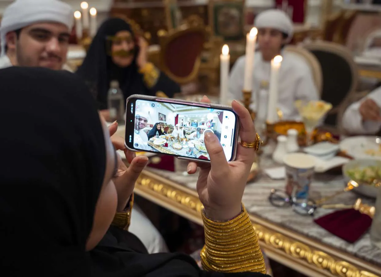 A granddaughter photographing Amina at the table