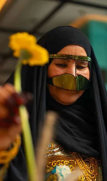 Amina smelling a yellow flower