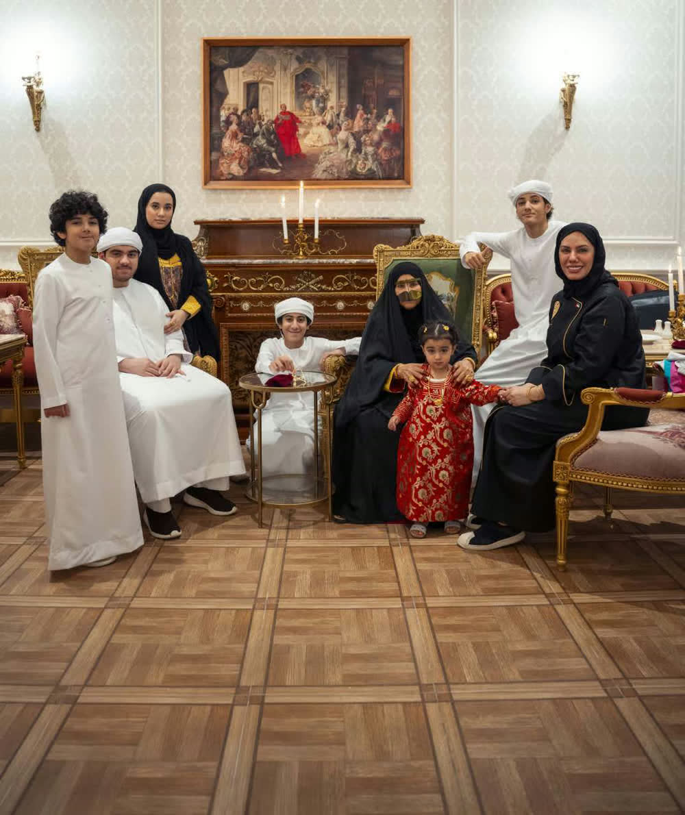 A family gathered in a majlis at Amina