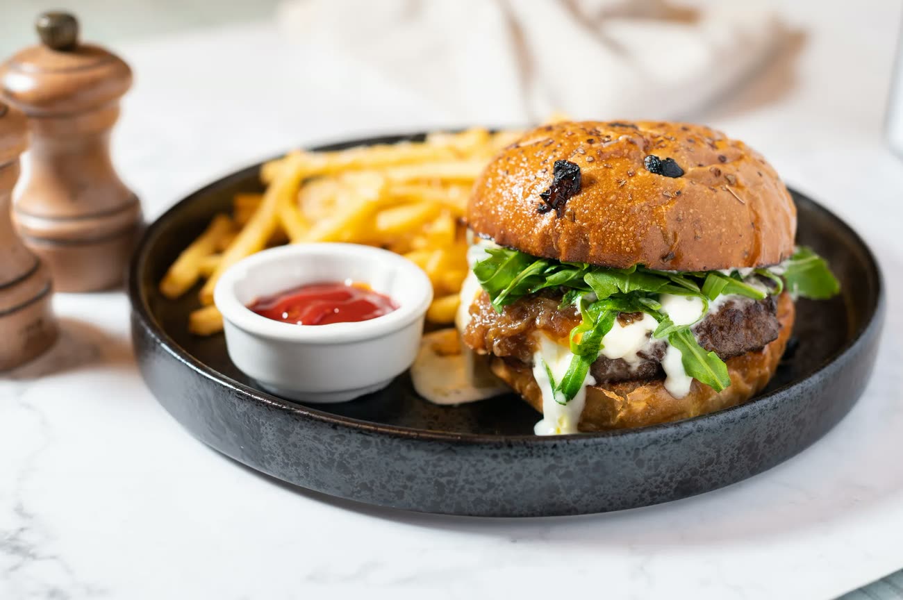 An MTK Smoke House burger and fries in a cast iron pan
